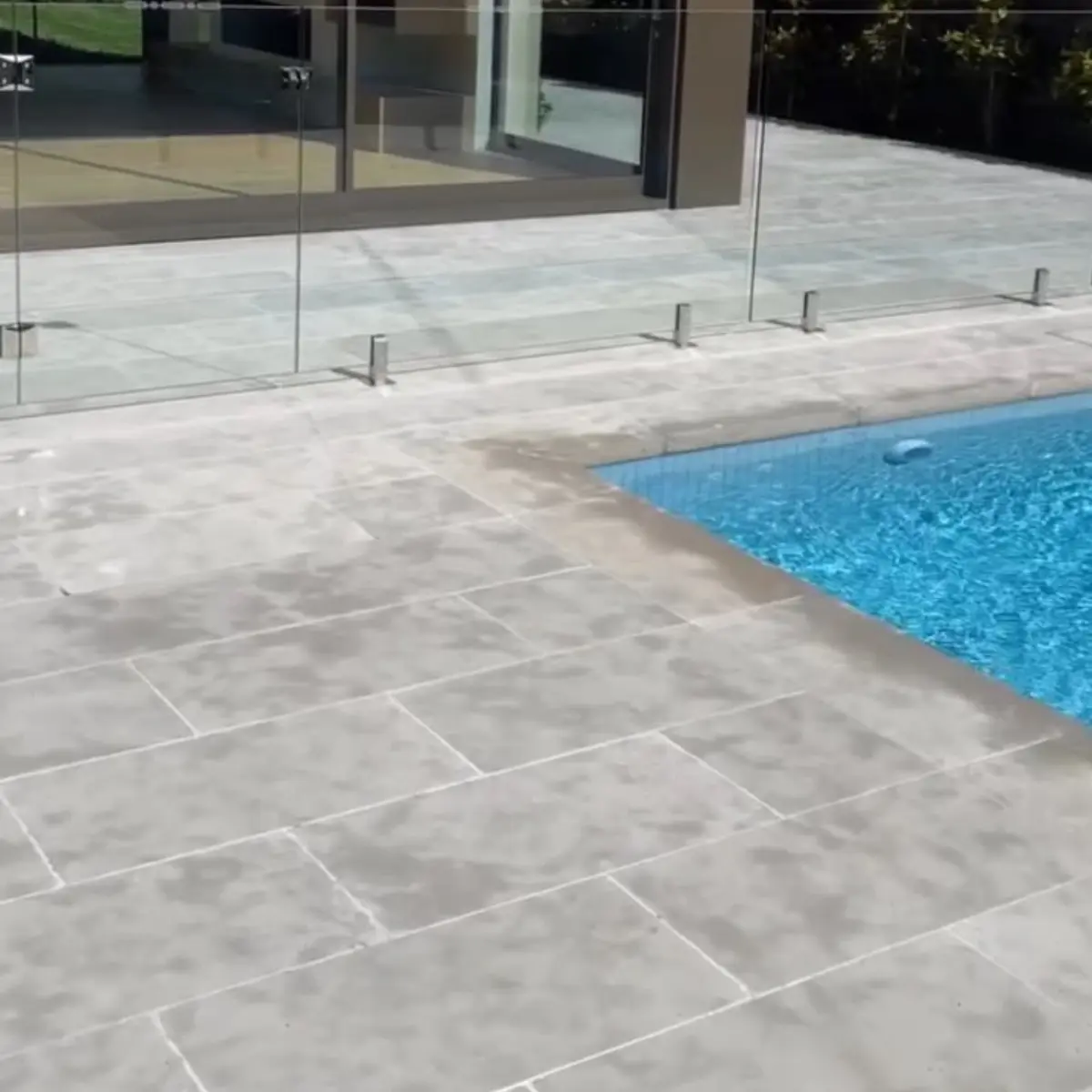 Resort style pool landscape with bluestone paving and sun lounges