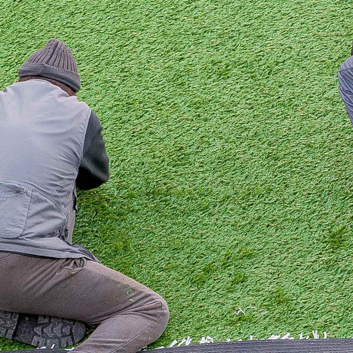 Synthetic turf courtyard surrounded by dark timber screening