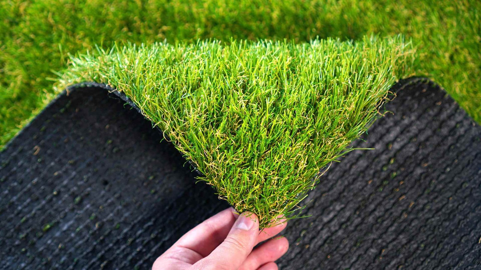 Ultra-realistic synthetic turf installed with pristine straight edge lines surrounding a modern poolside patio